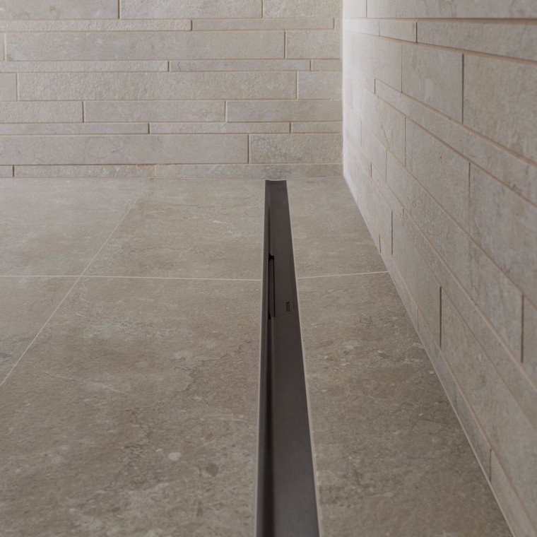 Вода стекает через элегантный канал из нержавеющей стали.