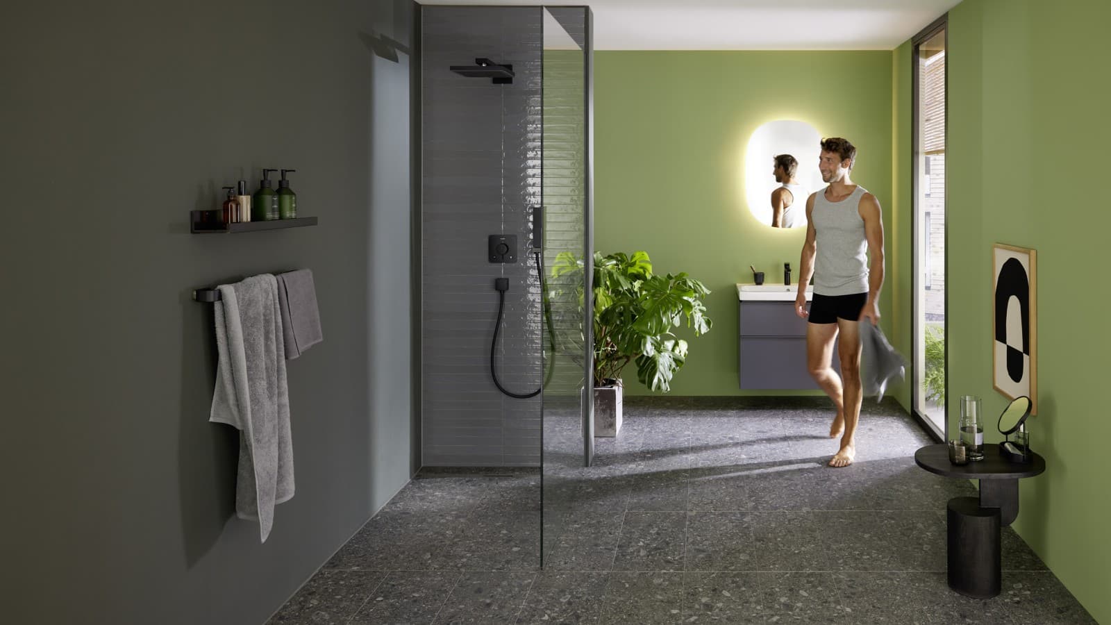 Молодой человек рядом с душевой зоной с Geberit CleanLine30 Молодой человек рядом с душевой зоной с Geberit CleanLine30